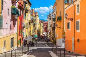 Rue colorée à Menton, France, journée ensoleillée.
