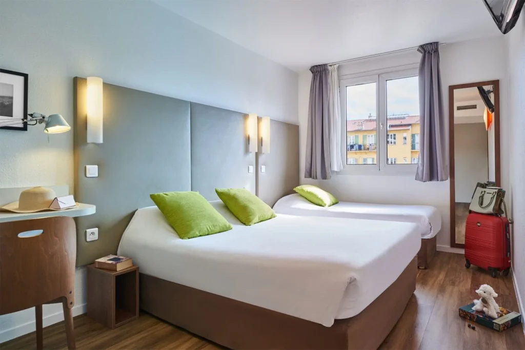 Chambre d'hôtel moderne avec deux lits.