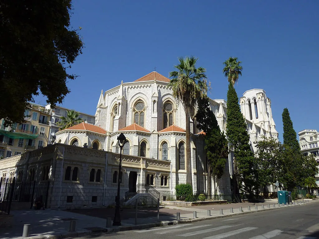 Église avec arbres et ciel bleu en arrière-plan.