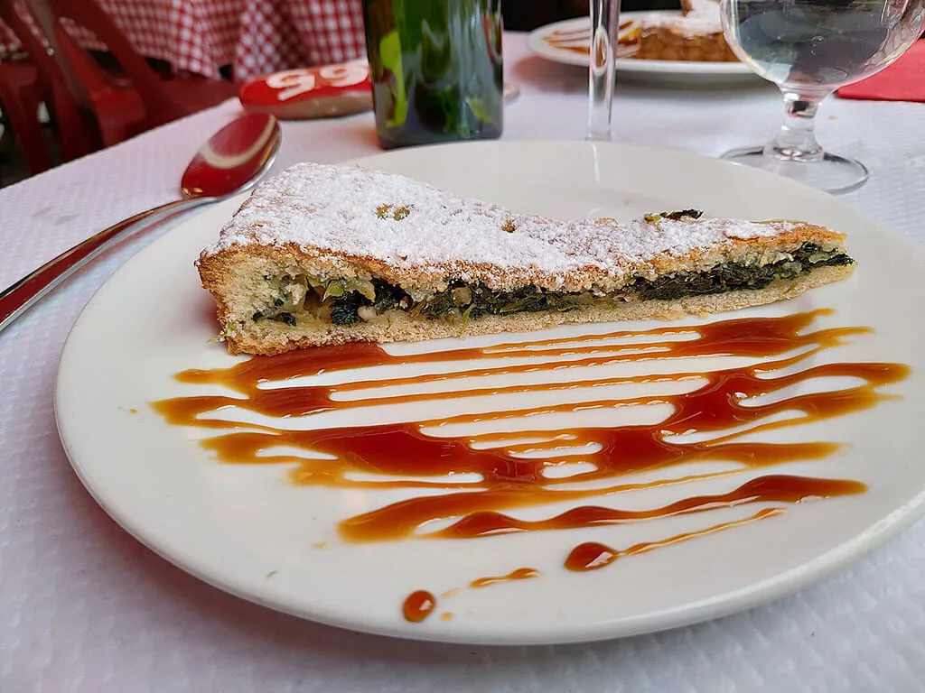 Part de tarte épinards, sauce caramel sur assiette.