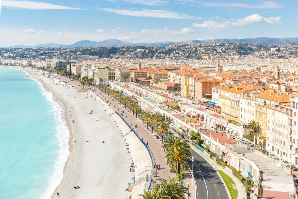 Vue aérienne de Nice avec plage et bâtiments.